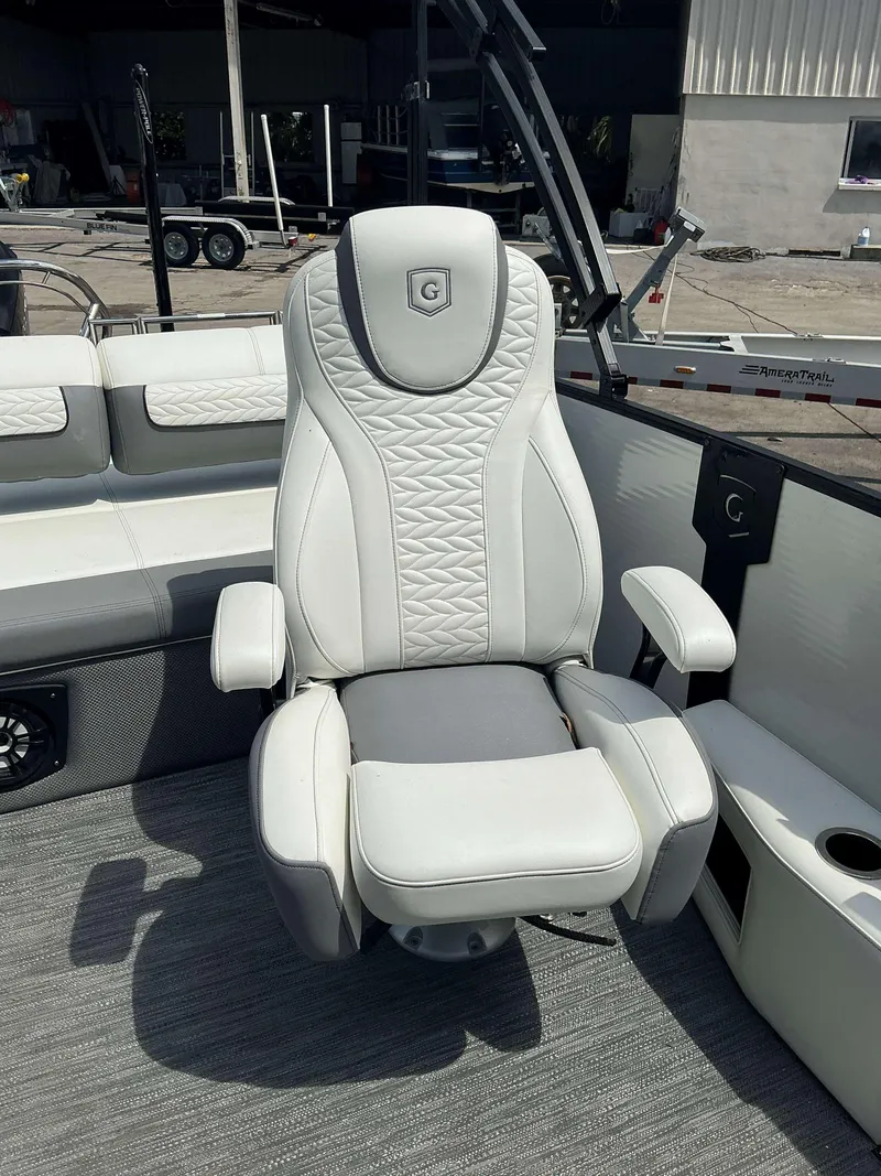 Slide: The Image of Luxurious captain's chair in 2023 MONACO 235 DFL boat, featuring elegant white upholstery. - 11