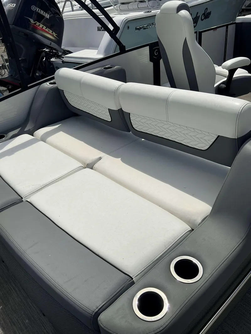 Slide: The Image of 2023 MONACO 235 DFL boat interior with cushioned seating and cup holders. - 12