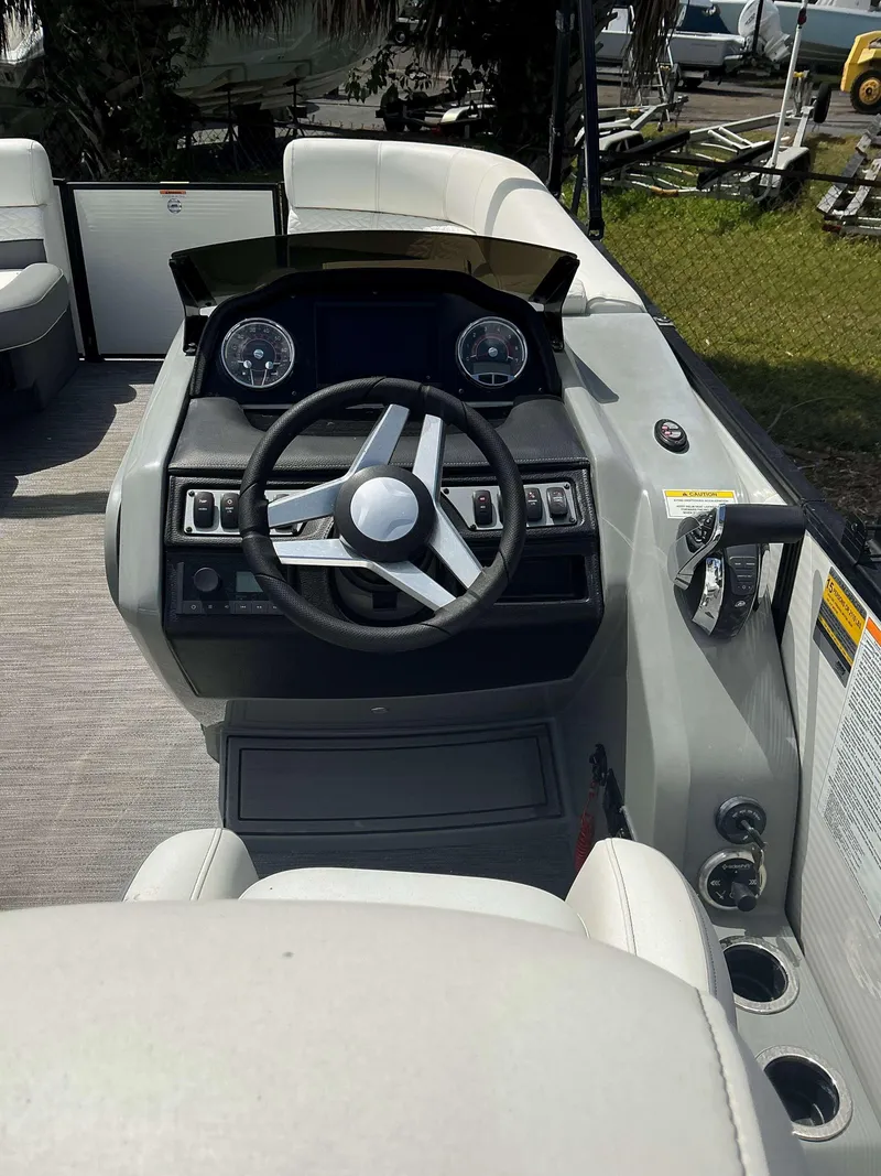 Slide: The Image of 2023 MONACO 235 DFL boat dashboard with steering wheel and control panel. - 6