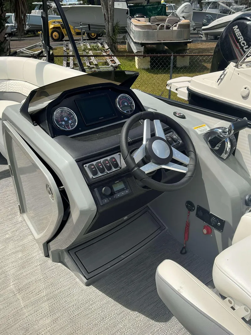 Slide: The Image of 2023 MONACO 235 DFL boat dashboard with steering wheel and control panel. - 7