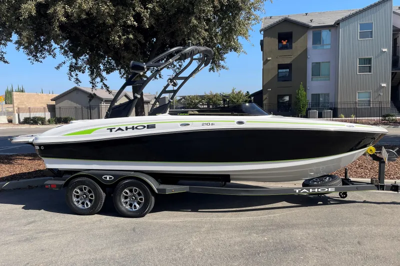 The Image of 2023 Tahoe 210 Si Limited boat on trailer, parked outdoors near buildings. - 0