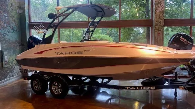 Slide: The Image of 2023 Tahoe 1950 boat on trailer, indoor display with large windows. - 0