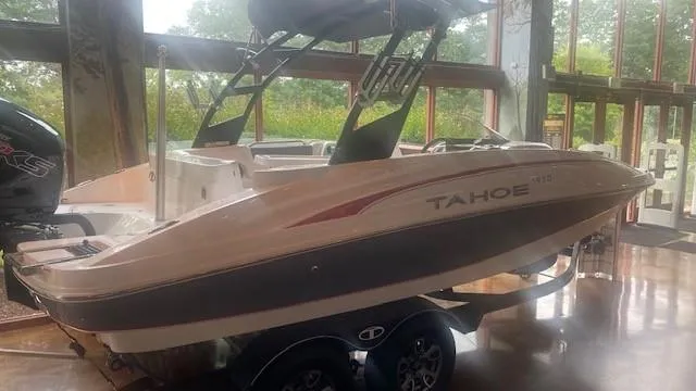 Slide: The Image of 2023 Tahoe 1950 boat on display indoors. - 1