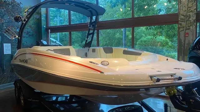 Slide: The Image of 2023 Tahoe 1950 boat on display indoors with a sleek white and red design. - 3