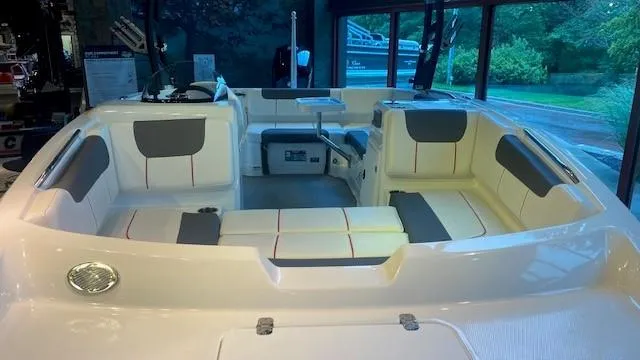 Slide: The Image of 2023 Tahoe 1950 boat interior with white and gray seating, docked indoors. - 4