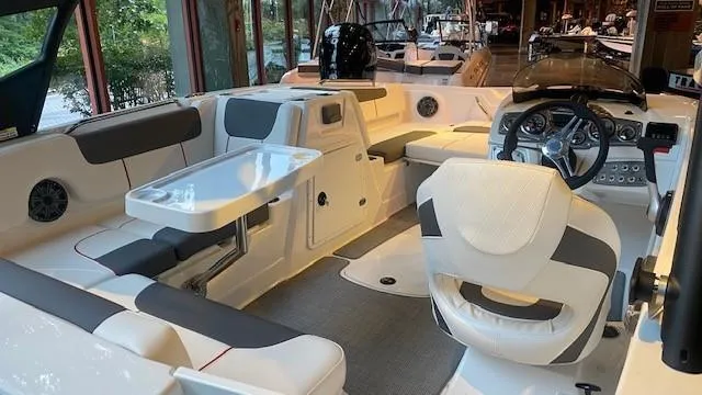Slide: The Image of 2023 Tahoe 1950 boat interior with seating, table, and steering console. - 5