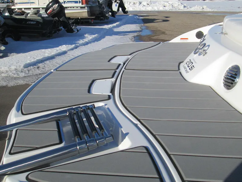 Slide: The Image of 2023 Tahoe 210 Si Limited boat with swim platform and ladder in snowy marina. - 13