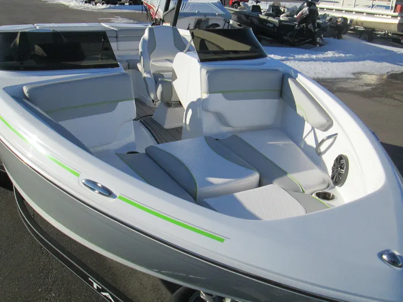 Slide: The Image of 2023 Tahoe 210 Si Limited boat with white and green interior, docked on a snowy day. - 17