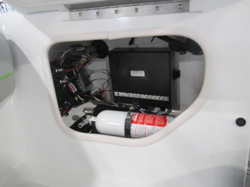 Slide: The Image of 2023 Tahoe 210 Si Limited boat interior compartment with wiring and fire extinguisher. - 43
