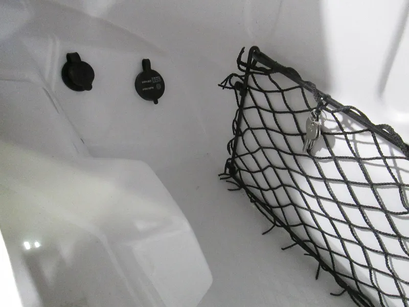 Slide: The Image of Interior storage compartment of 2023 Tahoe 210 Si Limited boat with netting and power outlets. - 48