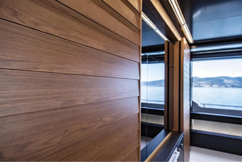 Slide: The Image of Interior of 2024 Riva 90' Argo yacht with wooden paneling and ocean view. - 17