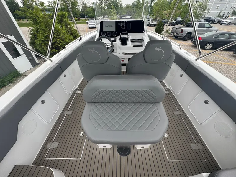 Slide: The Image of 2023 Iguana Sport boat interior with gray seating, Garmin dashboard, and sleek design. - 13