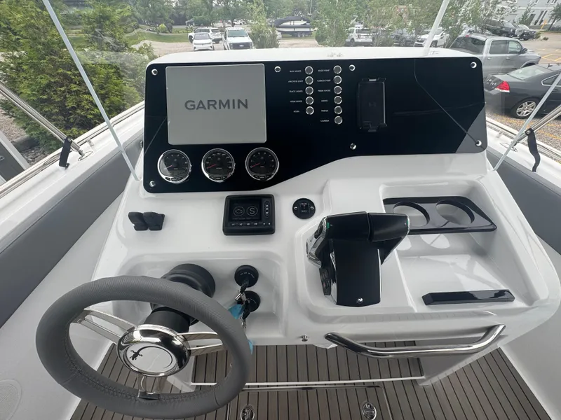 Slide: The Image of 2023 Iguana Sport boat dashboard with Garmin display and steering wheel. - 14