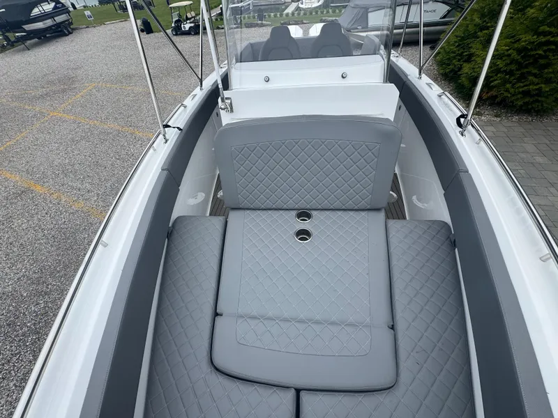 Slide: The Image of 2023 Iguana Sport boat interior with gray quilted seating and cup holders. - 16