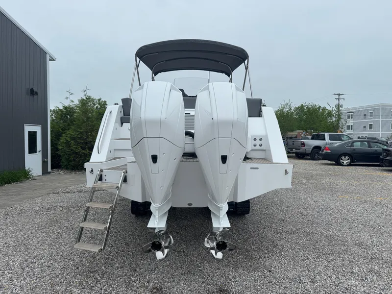 Slide: The Image of 2023 Iguana Sport boat with dual engines, parked on gravel near buildings. - 4