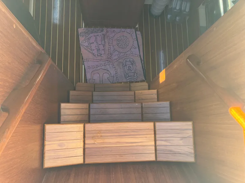 Slide: The Image of Wooden stairs inside a 1989 Pearson 39-2 boat, leading to a nautical-themed mat. - 18