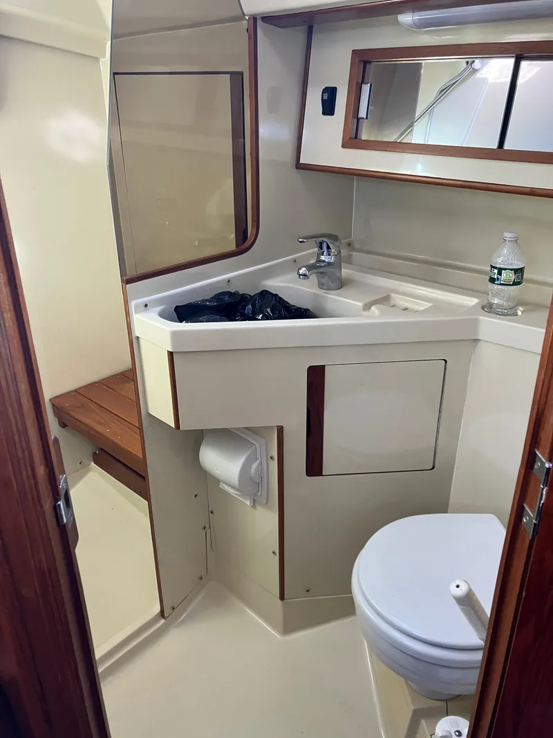 Slide: The Image of 1989 Pearson 39-2 yacht bathroom with sink, toilet, and wooden accents. - 32
