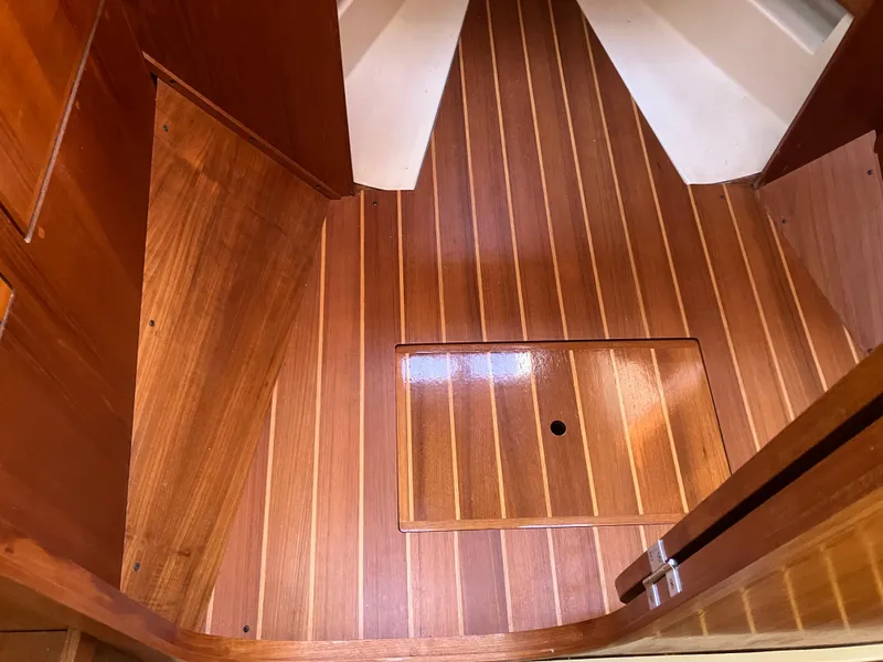Slide: The Image of Wooden interior flooring of a 1989 Pearson 39-2 sailboat, featuring a polished finish. - 36