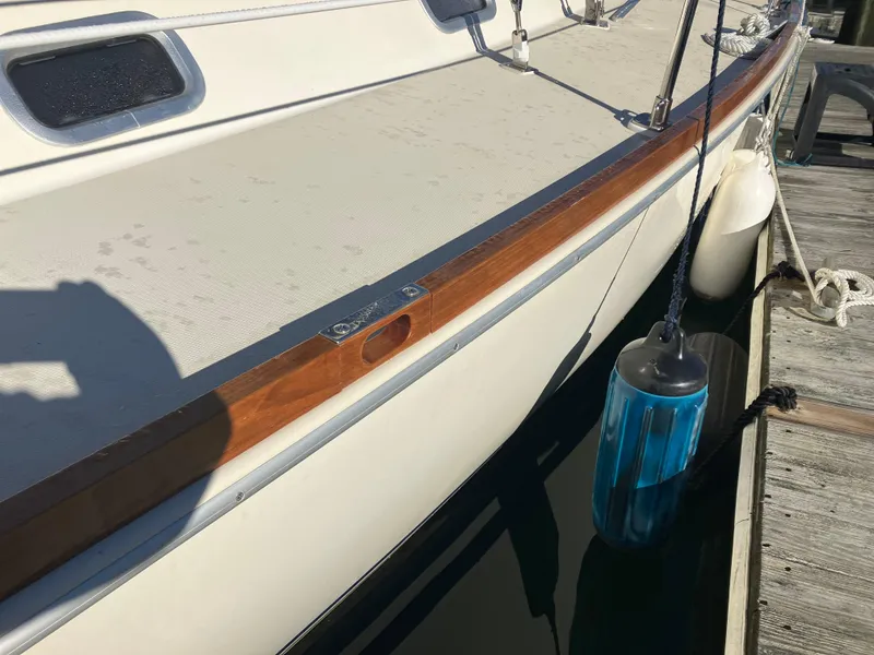 Slide: The Image of Pearson 39-2 sailboat from 1989 docked with blue fender and wooden trim. - 4