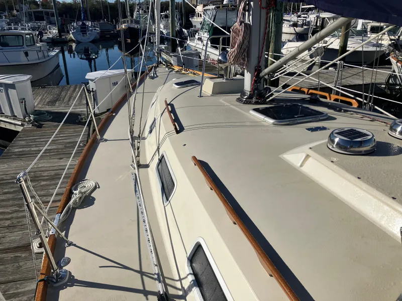 Slide: The Image of 1989 Pearson 39-2 sailboat deck view at marina, showcasing rigging and hatches. - 5