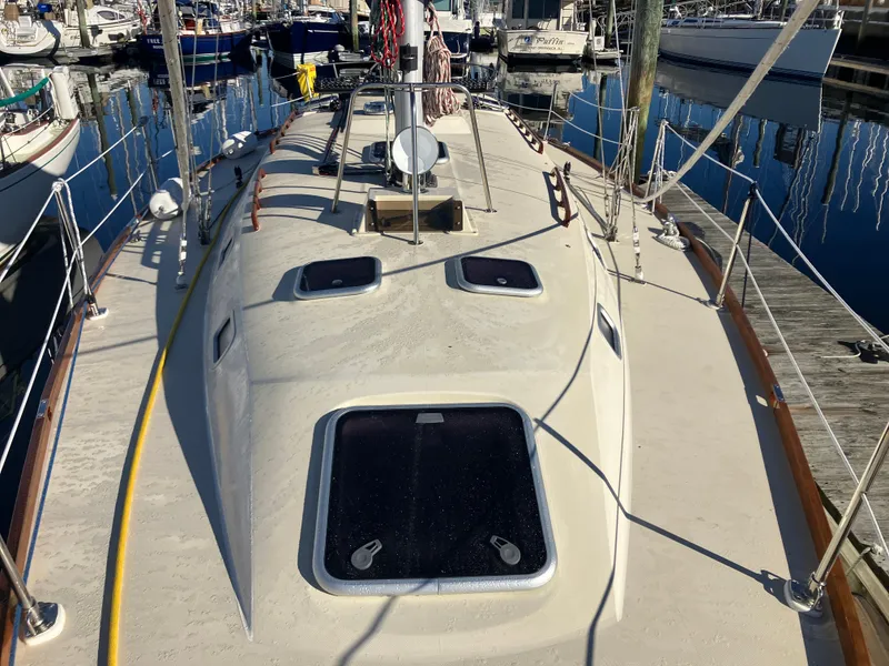 Slide: The Image of 1989 Pearson 39-2 sailboat deck view at marina, showcasing hatches and rigging. - 9