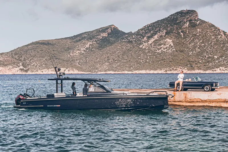 Slide: The Image of BRABUS Shadow 900 Deep Blue 2023 yacht docked by scenic mountains. - 27