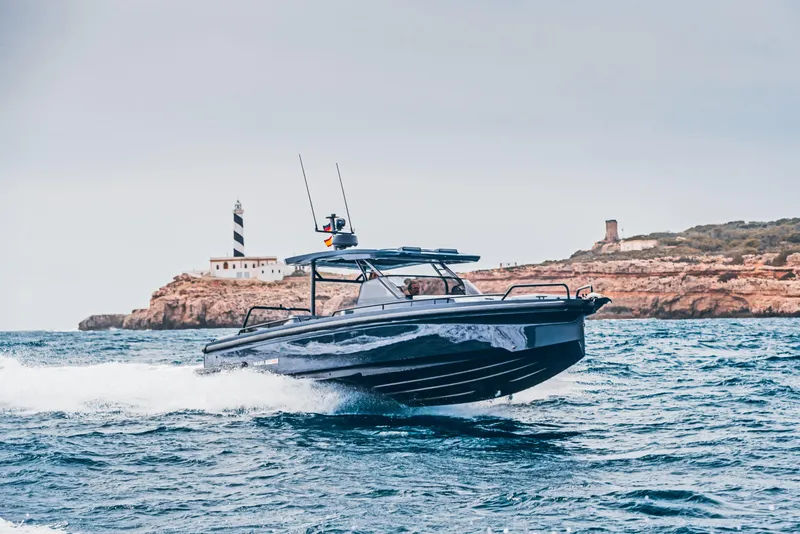 Slide: The Image of 2023 BRABUS Shadow 900 Deep Blue boat cruising near a coastal lighthouse. - 29