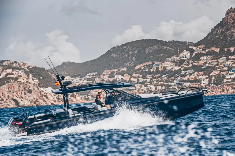 Slide: The Image of 2023 BRABUS Shadow 900 Deep Blue yacht cruising on the ocean near coastal mountains. - 30