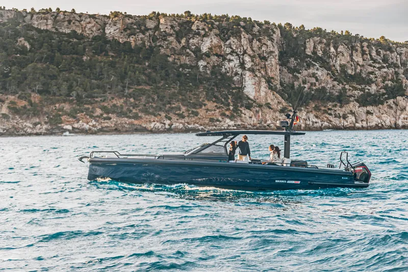 Slide: The Image of 2023 BRABUS Shadow 900 Deep Blue luxury boat cruising near rocky coastline. - 33