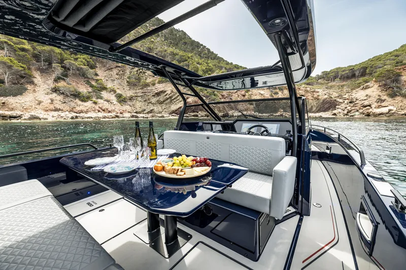 Slide: The Image of 2023 BRABUS Shadow 900 Deep Blue luxury yacht with dining area and scenic coastal view. - 37