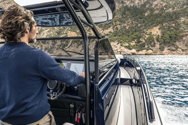 Slide: The Image of Man piloting 2023 BRABUS Shadow 900 Deep Blue boat on scenic water. - 38