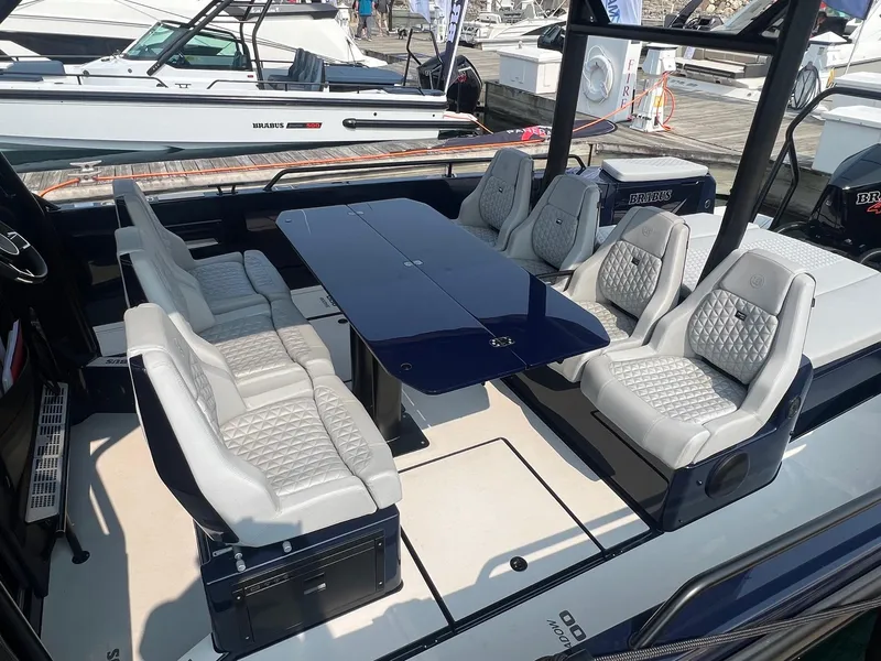 Slide: The Image of 2023 BRABUS Shadow 900 Deep Blue luxury boat interior with plush seating and sleek table. - 9