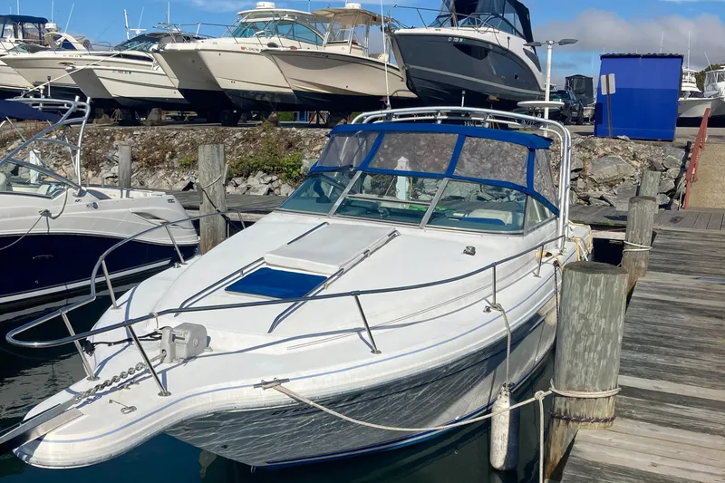Slide: The Image of 1992 Sea Ray 300 Weekender boat docked at marina, surrounded by other vessels. - 1