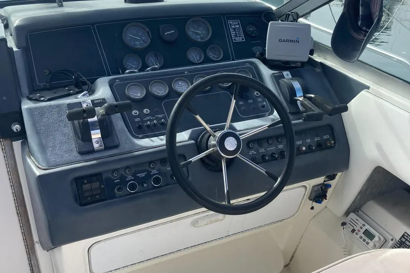 Slide: The Image of 1992 Sea Ray 300 Weekender helm with steering wheel, gauges, and Garmin navigation system. - 7