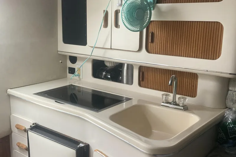 Slide: The Image of 1992 Sea Ray 300 Weekender boat kitchen with sink, stove, and cabinets. - 9