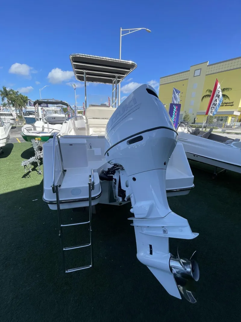 Slide: The Image of 2022 Wellcraft 220CC boat with outboard motor and ladder, displayed outdoors. - 10