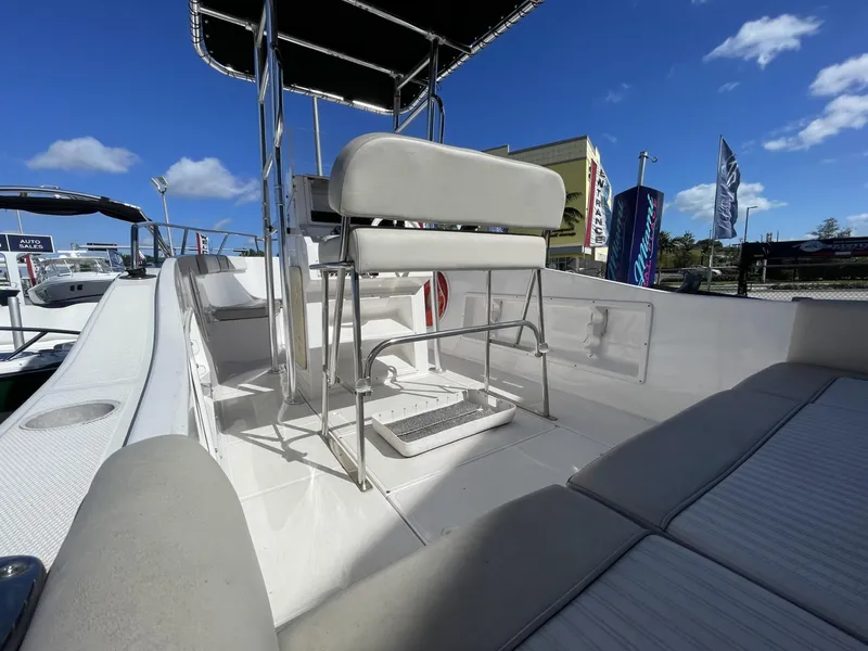 Slide: The Image of 2022 Wellcraft 220CC boat interior with seating and console under a clear blue sky. - 13