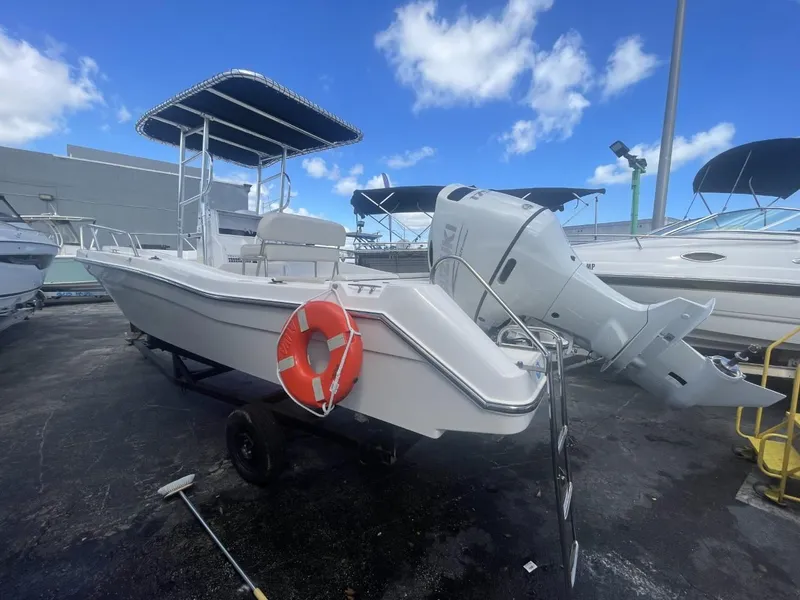 Slide: The Image of 2022 Wellcraft 220CC boat with outboard motor and T-top on trailer. - 2