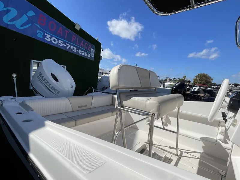 Slide: The Image of 2022 Wellcraft 220CC boat interior with Suzuki outboard motor at a dealership. - 5