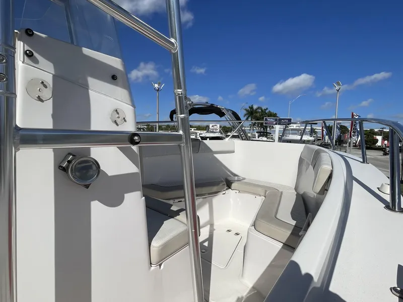 Slide: The Image of 2022 Wellcraft 220CC boat interior with seating, stainless steel railings, and blue sky background. - 6