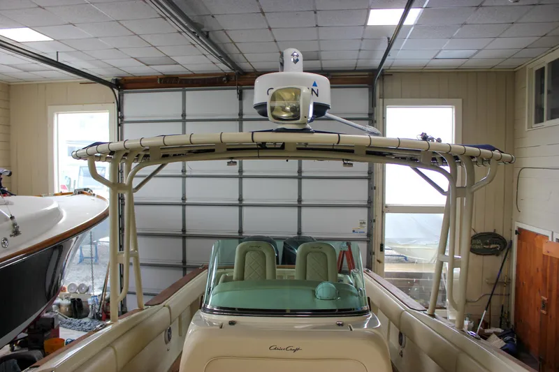 Slide: The Image of 2014 Chris-Craft Catalina 29 Sun Tender in a garage, showcasing its helm and radar equipment. - 24