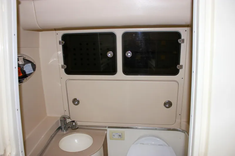 Slide: The Image of 2014 Chris-Craft Catalina 29 Sun Tender bathroom with sink, storage cabinets, and toilet. - 29
