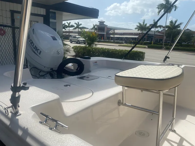 Slide: The Image of 2023 Carolina Skiff 162 JLS boat with Suzuki outboard motor, docked near a marina. - 11
