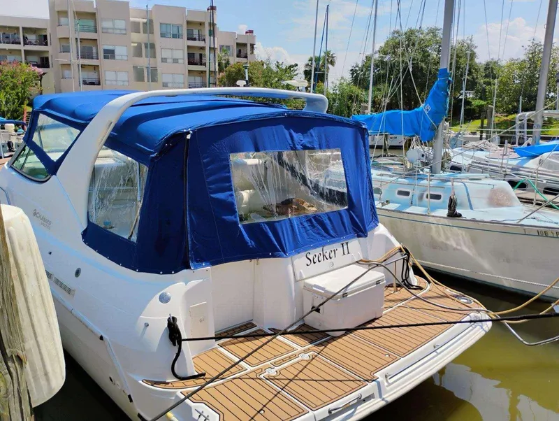 Slide: The Image of 1998 Cruisers Yachts 3375 Esprit docked, featuring blue canopy and wooden deck. - 38