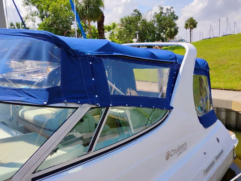 Slide: The Image of 1998 Cruisers Yachts 3375 Esprit with blue canopy docked near greenery. - 40
