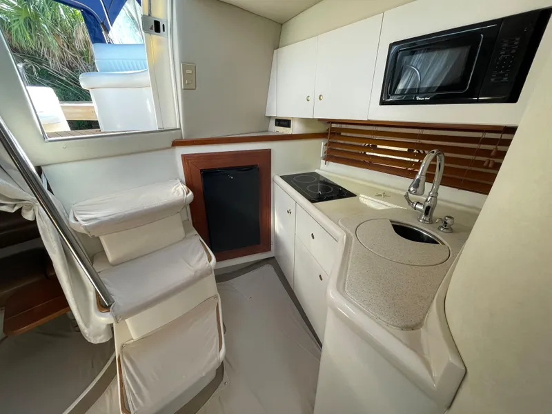 Slide: The Image of 1998 Cruisers Yachts 3375 Esprit interior kitchen with microwave, sink, and compact design. - 29