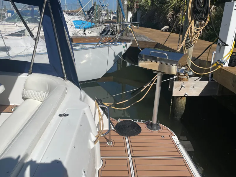 Slide: The Image of 1998 Cruisers Yachts 3375 Esprit docked, featuring a spacious deck and marina view. - 6