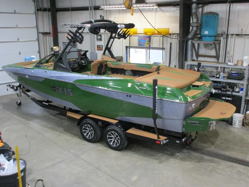 Slide: The Image of 2023 Axis A24 green and silver boat on trailer in a garage. - 19