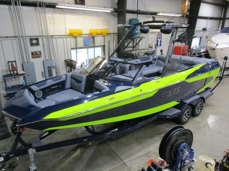 Slide: The Image of 2023 Axis A24 boat with neon green and navy blue design in a showroom. - 10