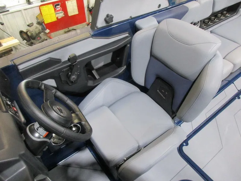 Slide: The Image of 2023 Axis A24 boat interior with gray captain's seat and steering wheel. - 11